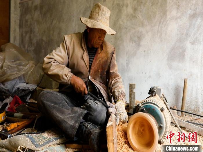 圖為手工藝人正在制作木碗?！?鄧海平 攝