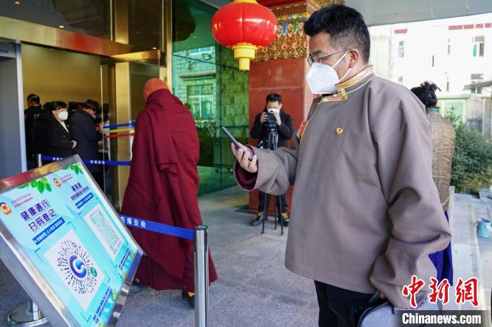 圖為政協(xié)委員掃場所碼進(jìn)入會場?！〗w波 攝