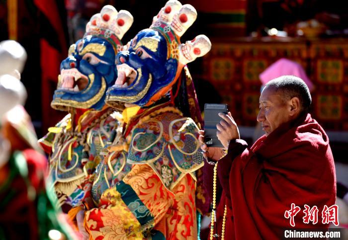 2月19日，正在拍攝跳神活動的僧人。　李林 攝