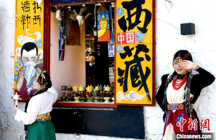 4月17日，游客身著藏式元素服裝在拉薩八廓街拍照留念。　李林 攝