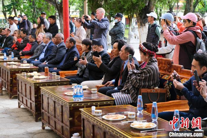 5月19日，中外嘉賓在羅布林卡和游客一起觀看藏戲?！〗w波 攝