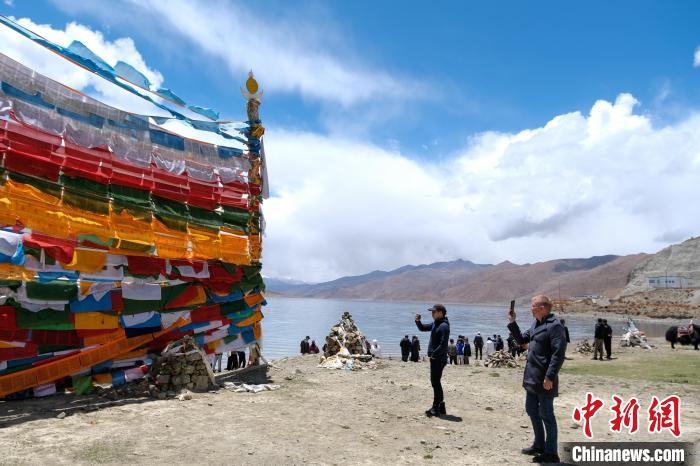 進藏參訪嘉賓在羊湖畔拍攝經(jīng)幡?！〗w波 攝