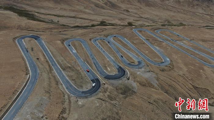 圖為騎手前往珠峰大本營途經(jīng)108道拐?！∮文恋厍蚬﹫D