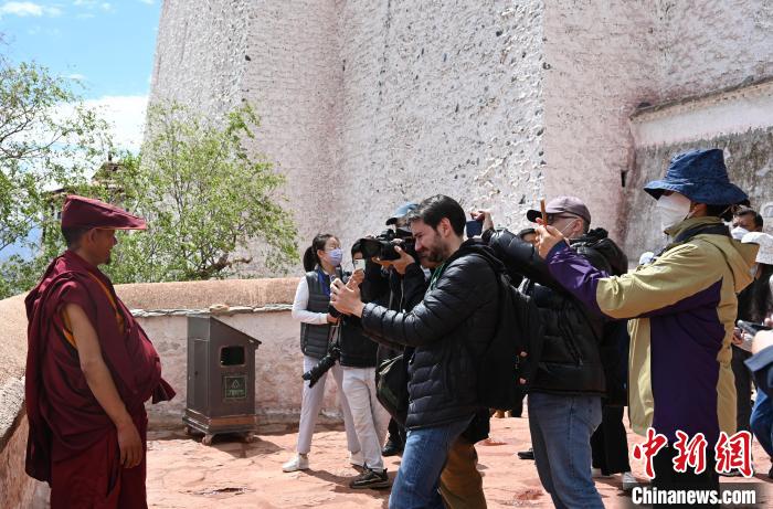 圖為中外媒體拍攝朝拜布達拉宮的僧人?！≮w朗 攝