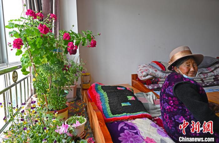 圖為曲松縣特困人員集中供養(yǎng)中心老人德吉卓嘎與她的花?！≮w朗 攝