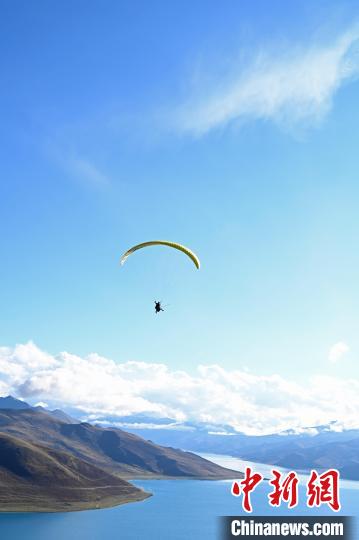 圖為在羊卓雍錯，游客體驗高空滑翔?！≮w朗 攝