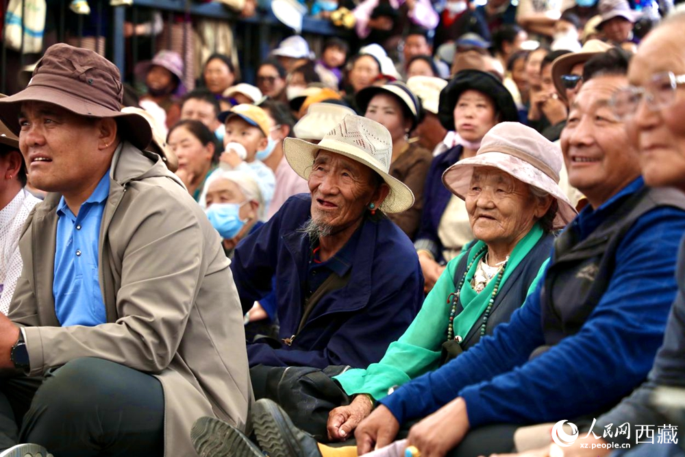 當(dāng)?shù)厝罕姾陀慰陀^看藏戲演出。