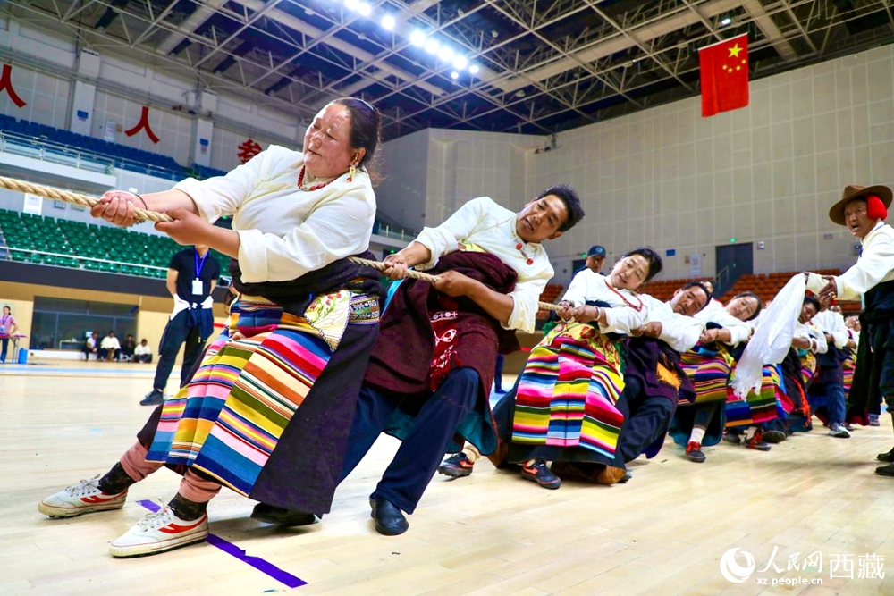 身著民族服裝的農(nóng)牧民選手在拔河比賽現(xiàn)場。
