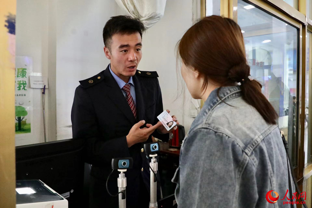 車站工作人員向旅客解答疑問。人民網(wǎng)記者 次仁羅布攝