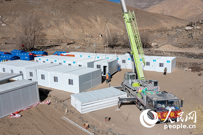 1月9日，在日喀則市定日縣長所鄉(xiāng)古榮村安置點，救援人員和施工人員合力抓緊搭建移動板房，確保受災群眾溫暖過冬。人民網記者 翁奇羽攝