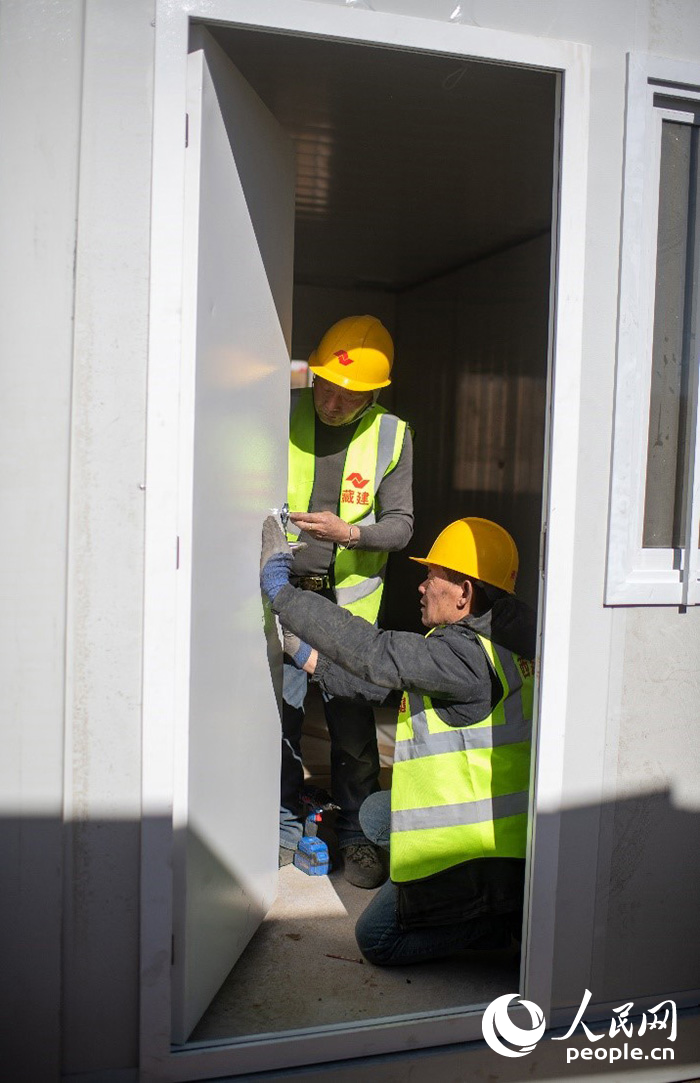 1月9日，在日喀則市定日縣長所鄉(xiāng)古榮村安置點，施工人員正在抓緊搭建移動板房，確保受災群眾溫暖過冬。人民網記者 翁奇羽攝