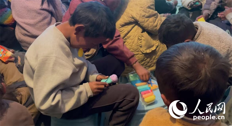 措果鄉(xiāng)塘仁村的孩子們正在用橡皮泥制作自己的情緒“小怪獸”。人民網(wǎng)記者 郝潔攝