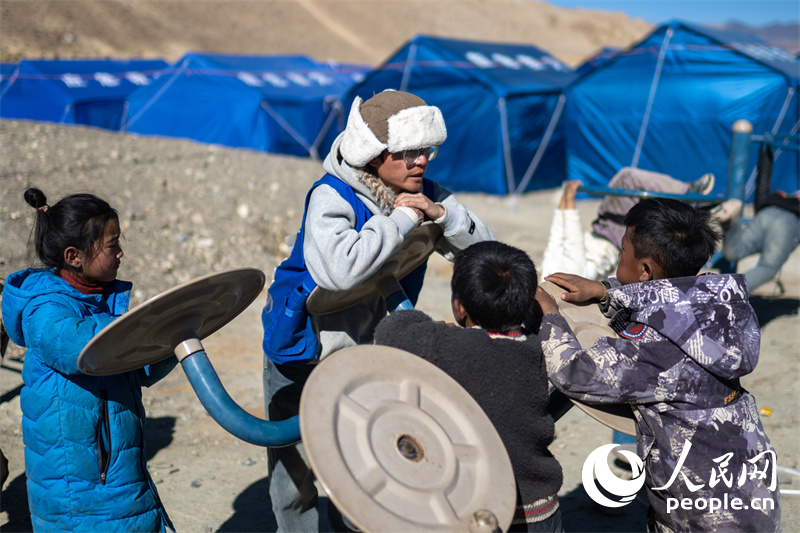 西藏星光社會(huì)工作服務(wù)中心社工久米旦增通過(guò)聊天談心，對(duì)孩子們進(jìn)行災(zāi)后心理疏導(dǎo)。人民網(wǎng)記者 翁奇羽攝
