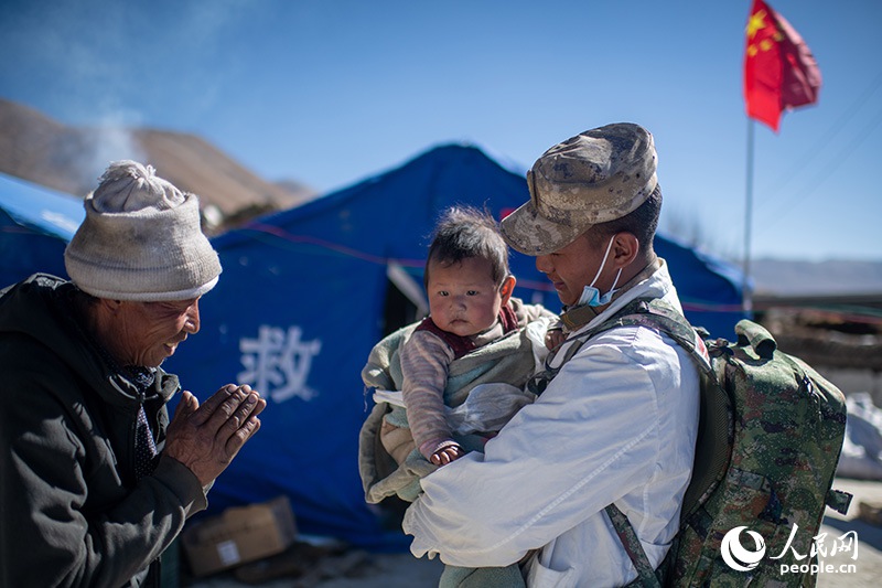 1月9日，在定日縣長所鄉(xiāng)古榮村安置點，受災(zāi)群眾感謝西藏軍區(qū)陸軍某部隊衛(wèi)生員的醫(yī)療救治。人民網(wǎng)記者 翁奇羽攝
