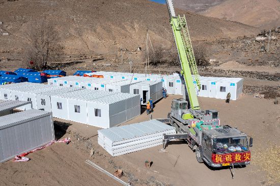 2025年1月9日，在定日縣長所鄉(xiāng)古榮村安置點(diǎn)，救援人員和施工人員合力抓緊搭建移動板房，確保受災(zāi)群眾溫暖過冬。人民網(wǎng)記者 翁奇羽攝