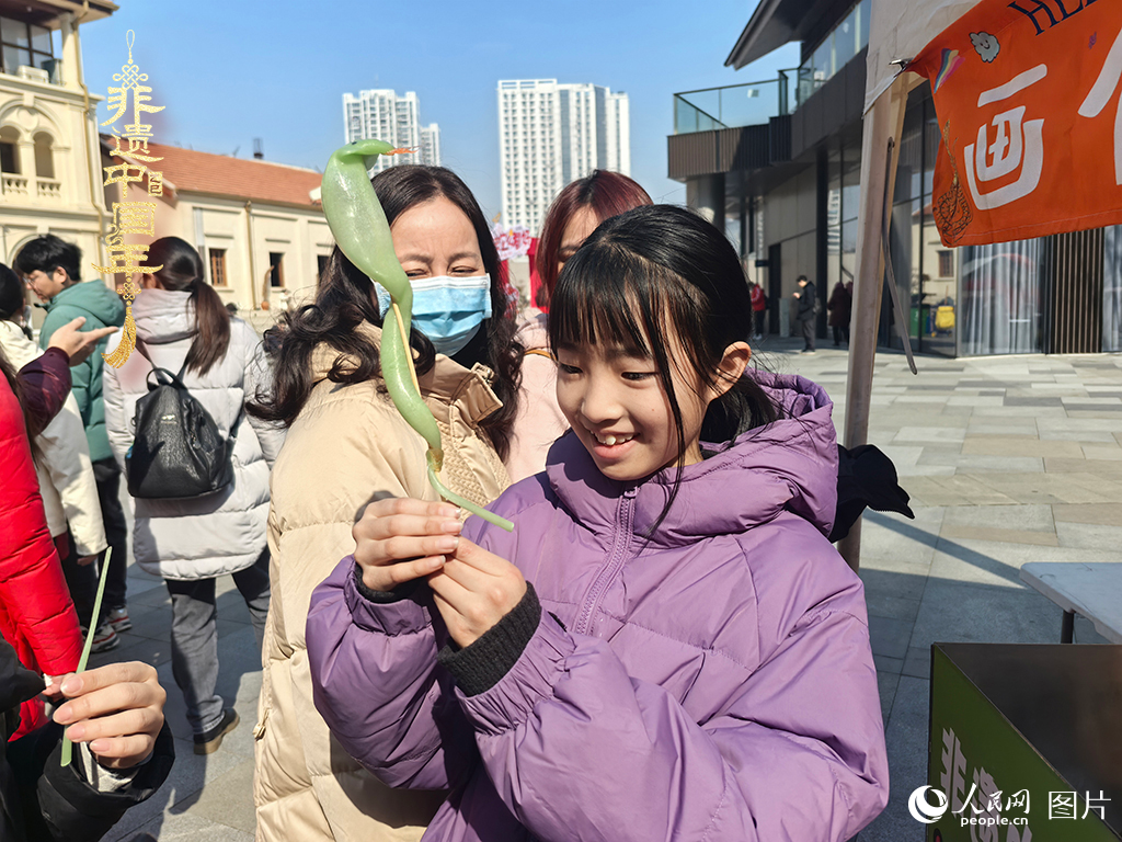 2025年1月29日，湖北武漢的新春廟會(huì)上，小朋友拿著吹制好的糖人，十分開心。人民網(wǎng)記者 張沛攝