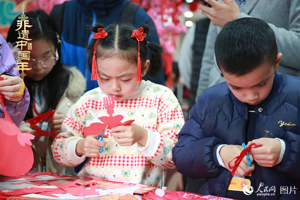 2025年1月23日，上海市青少年活動(dòng)中心迎新春游園會(huì)上，小朋友們正在學(xué)習(xí)剪窗花。人民網(wǎng)記者 龔莎攝