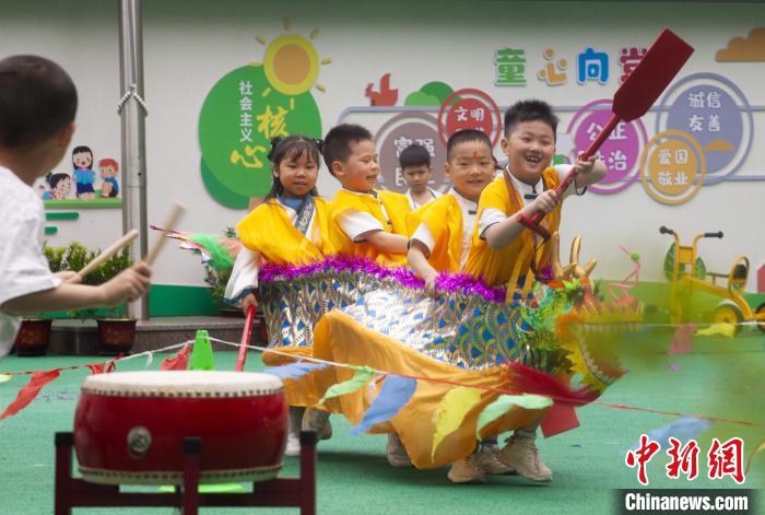 圖為龍舟賽游戲上，小伙伴們打鼓加油?！《^生 攝