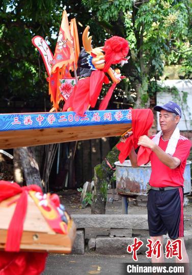 圖為5月29日，長(zhǎng)樂江田鎮(zhèn)村民為即將入水的新龍舟系紅布?！埍?攝