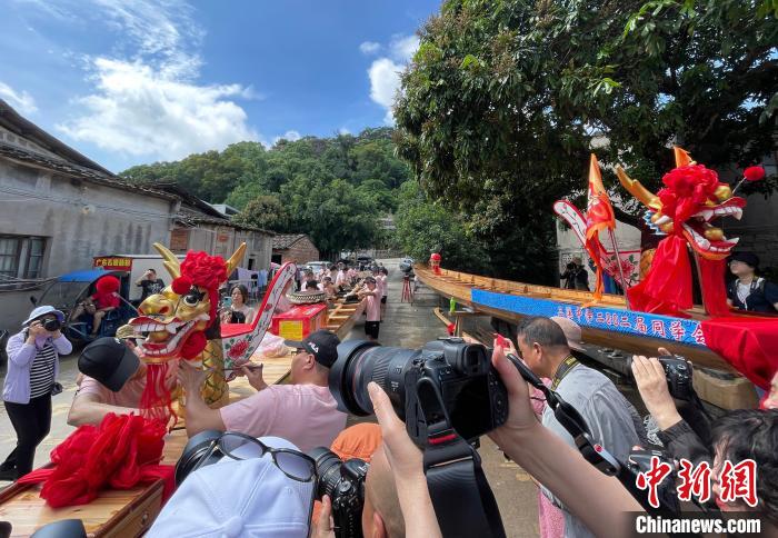 圖為5月29日，長(zhǎng)樂江田鎮(zhèn)村民為即將入水的新龍舟安裝龍頭。　張斌 攝