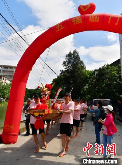 圖為5月29日，長(zhǎng)樂江田鎮(zhèn)村民們推著新龍舟前行?！埍?攝