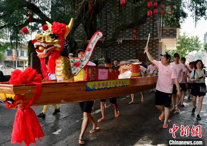 圖為5月29日，長(zhǎng)樂江田鎮(zhèn)村民們推著新龍舟前行?！埍?攝