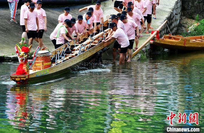圖為5月29日，長(zhǎng)樂江田鎮(zhèn)村民們齊力推新龍舟下水?！埍?攝