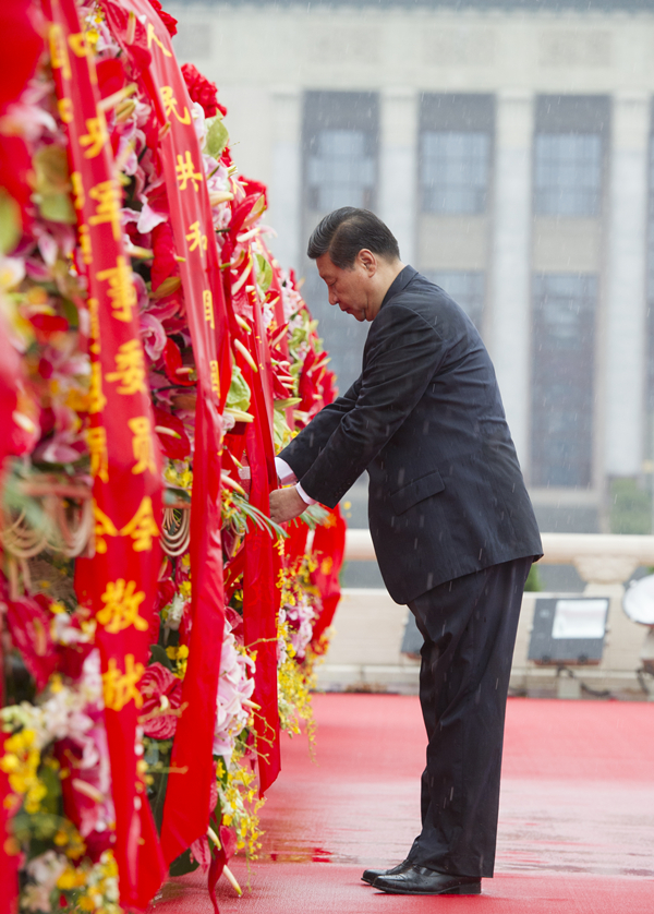 2013年10月1日上午，在首都各界代表向人民英雄紀(jì)念碑敬獻(xiàn)花籃儀式上，習(xí)近平整理花籃上的緞帶。